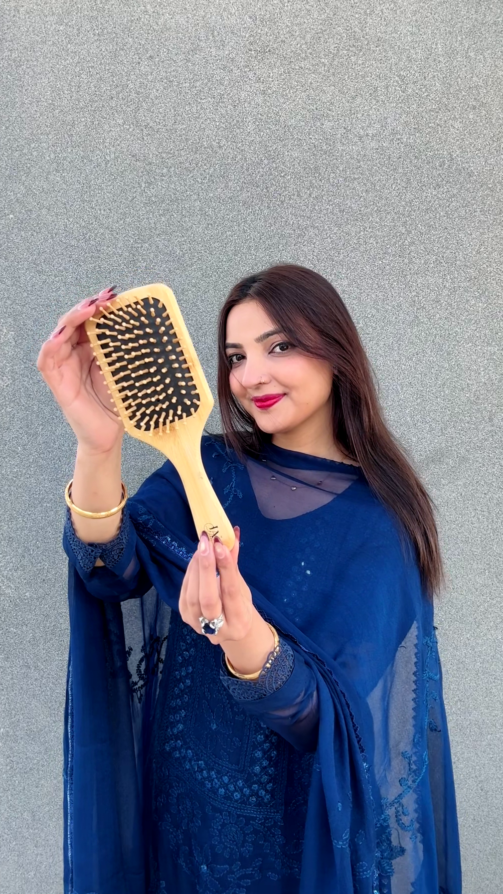 Woman holding a yellow hairbrush against a Clean Background